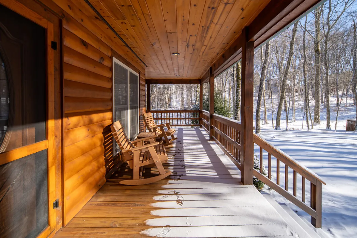 This image showcases a wooden porch with classic rocking chairs, overlooking a snow-covered landscape. The scene is tranquil and inviting, suggesting a peaceful environment for relaxation or thoughtful breaks during a work retreat.